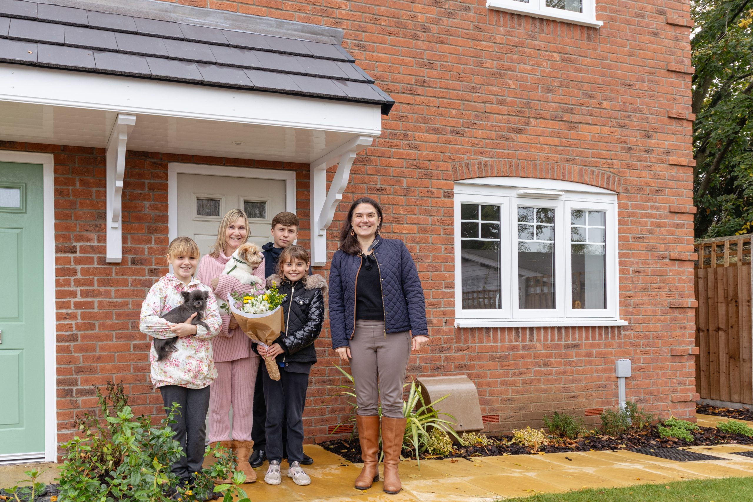 Family with Councillor Victoria Atherstone outside their new affordable home at Hillfort Place, Leckhampton.