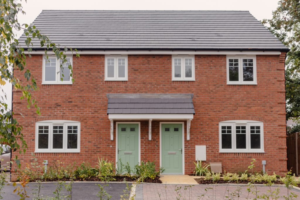 New homes at Hillfort Place, Shurdington Road, Cheltenham. Red brick semi-detatched with white windows and light green doors